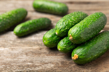 Cucumber on wooden background. Slice of cucumber on background. Fresh organic green cucumbers gherkin. Vegan. Salad ingredient. Farm vegetables. Cut vegetables with knife. Space for text. Copy space