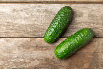 Cucumber on wooden background. Slice of cucumber on background. Fresh organic green cucumbers gherkin. Vegan. Salad ingredient. Farm vegetables. Cut vegetables with knife. Space for text. Copy space