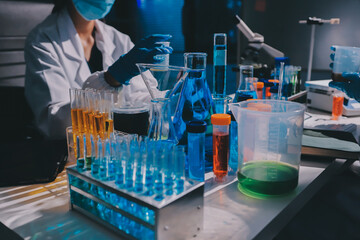 Scientist pipetting medical samples into microplate in laboratory
