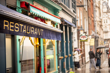 Central London west end street scene with restaurant text on left third of composition