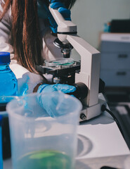 Scientist pipetting medical samples into microplate in laboratory