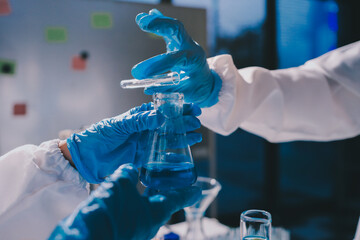 Scientist pipetting medical samples into microplate in laboratory