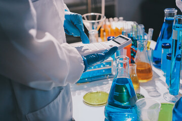 Scientist pipetting medical samples into microplate in laboratory