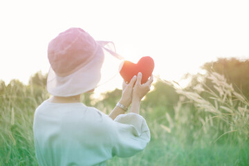 Woman holding red heart in hands, closeup.
