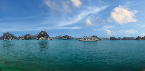 Fototapeta premium Halong Ha Long Bay Hanoi this Vietnamese wonder is littered with mountains and Rock cliffs popping out of the ocean, lush green mountains in Vietnam