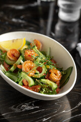 Portion of gourmet salad with fresh vegetables and shrimp