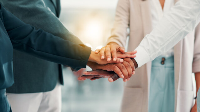 Business people, meeting and hands together with team for motivation, mission or inclusion at office. Closeup, group or employees piling with stack in huddle for unity, collaboration or cooperation