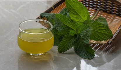 cup of mint tea and a sprig of mint on the table