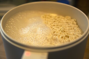 A steaming bowl of savory soup with noodles.