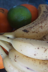 A few ripe bananas rest on a natural surface, revealing their golden glow and slightly textured appearance. 