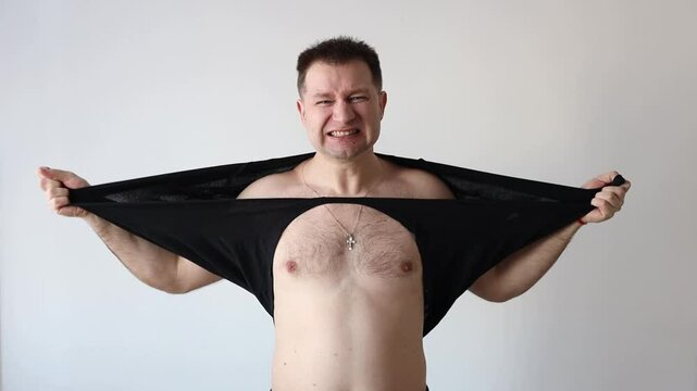 Strong man rips his shirt off