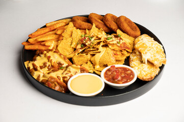 Fish & Chips — Crispy battered and crumb-fried fillet of fish served with golden fries, tartare sauce, and sautéed beans, presented on a black plate against a white background.