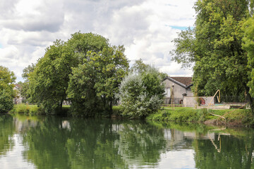 Obraz premium A calm body of water with trees in the background in Cognac France
