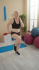 Woman exercising in gym wearing black sportswear showcasing albinism in a bright interior with...