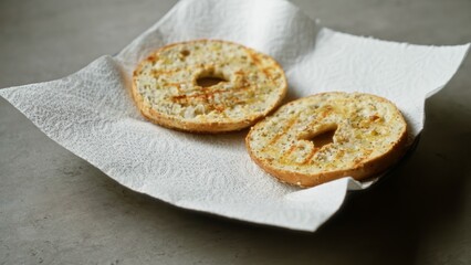 Bagels placed on paper napkins over a concrete surface showcasing a simple breakfast setting emphasizing food presentation and texture.