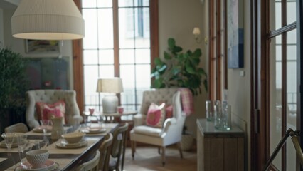 Blurred view of a cozy living room with elegant furniture, large windows, and soft lighting, creating a warm indoor atmosphere perfect for relaxation and leisure.