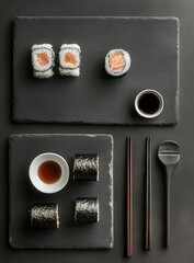 Elegant sushi arrangement on slate plates with soy sauce and chopsticks