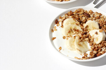 Honey Granola with Yogurt, Banana, Nuts and Seeds Served on White Background. Healthy Breakfast.