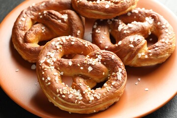 Tasty pretzels with salt on table, closeup