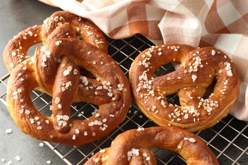 Tasty pretzels with salt on grey table, above view