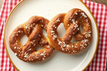 Tasty pretzels with salt on table, top view