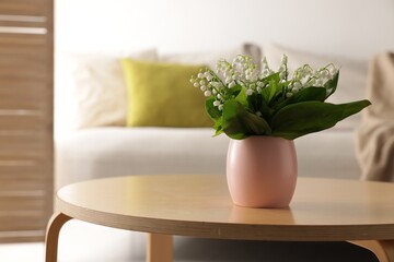 Bouquet of beautiful lily-of-the-valley on coffee table indoors