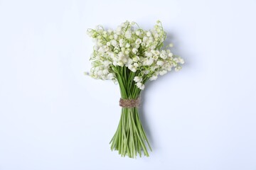Beautiful lily-of-the-valley flowers on white background, top view