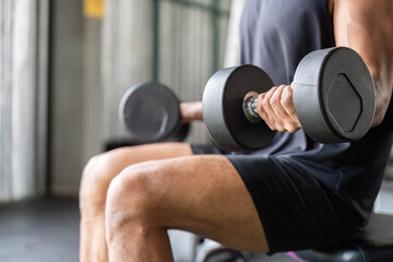 Focused Fitness Routine: Man Lifting Dumbbells while Seated.