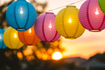 Obraz premium Colorful Paper Lanterns Illuminated at Sunset Outdoor Party Decoration