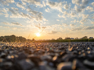 Obraz premium A stunning and beautiful sunset casts a warm golden light over a pebbled landscape, creating a truly serene atmosphere