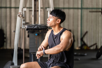 Fitness Training. Focused man checking fitness tracker during workout at gym.