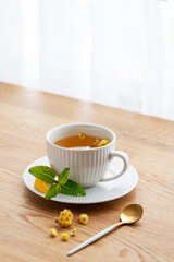 Cup of herbal tea with lemon, honey and mint on wooden tabletop