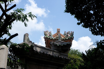 The eaves of a traditional Chinese building under a clear sky and tree