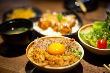 A close up side dish tomato green salad Japanese kyudou grilled pork with Marinated egg yolk and rice bowl serve with salted pickled egg yolk and miso food set 