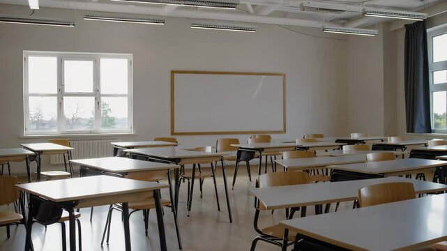 Modern empty classroom interior with clean desks, blackboard and wide bright windows, minimal academic learning space in calm educational environment