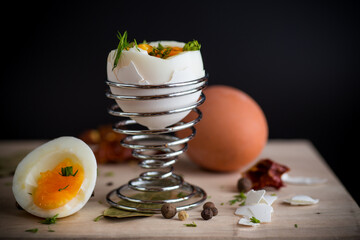 morning soft boiled egg in egg cup isolated on black background