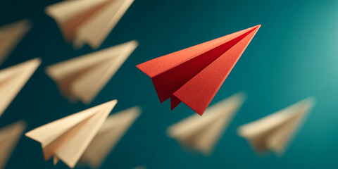 Red paper airplane leading beige planes against teal background, symbolizing leadership, innovation, and standing out from the crowd