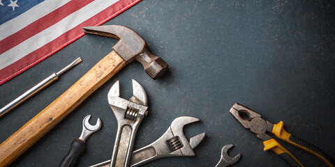 Industry background. Construction industry with tools concept of Labor Day against a concrete background featuring the American flag. Celebration of work, hammer, wrench, pliers, screwdriver