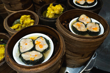 Various dimsum or dumplings menus in bamboo steamers piled up in Chinese restaurants.