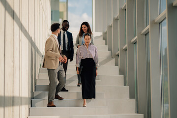 Business people walking down stairs in modern office building