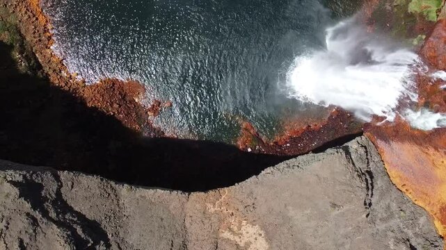 outstanding waterfall with orange and blue colors as the acid water flows in Salto del Agrio in Argentina