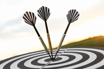 Targeting. Dart board with arrows outdoors, closeup