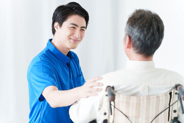 Obraz premium 男性介護士と車椅子に乗った高齢者男性