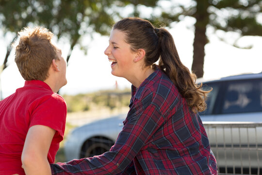 Teenage boy and girl laughing together outside