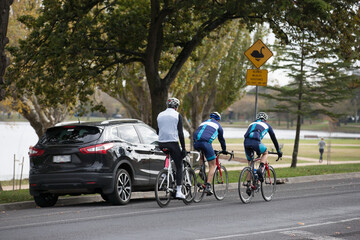 Group of cyclists riding on a bike path around a lake
