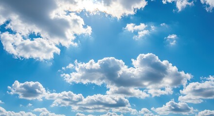 Bright blue sky with fluffy clouds illuminated by sunlight, serene atmosphere