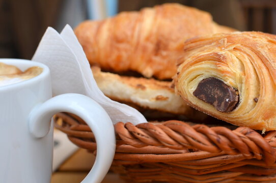 Close-up of a croissant, pain au chocolat and coffee breakfast on a table