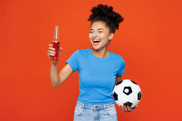 Young cool satisfied woman fan wearing basic blue t-shirt cheer up support football sport team hold...