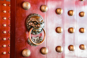 Door knob on a red gate of a chinese temple, Chinatown district, Singapore city