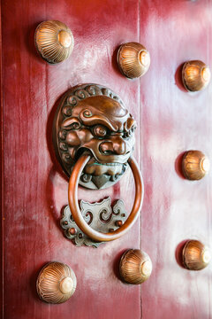 Door knob on a red gate of a chinese temple, Chinatown district, Singapore city